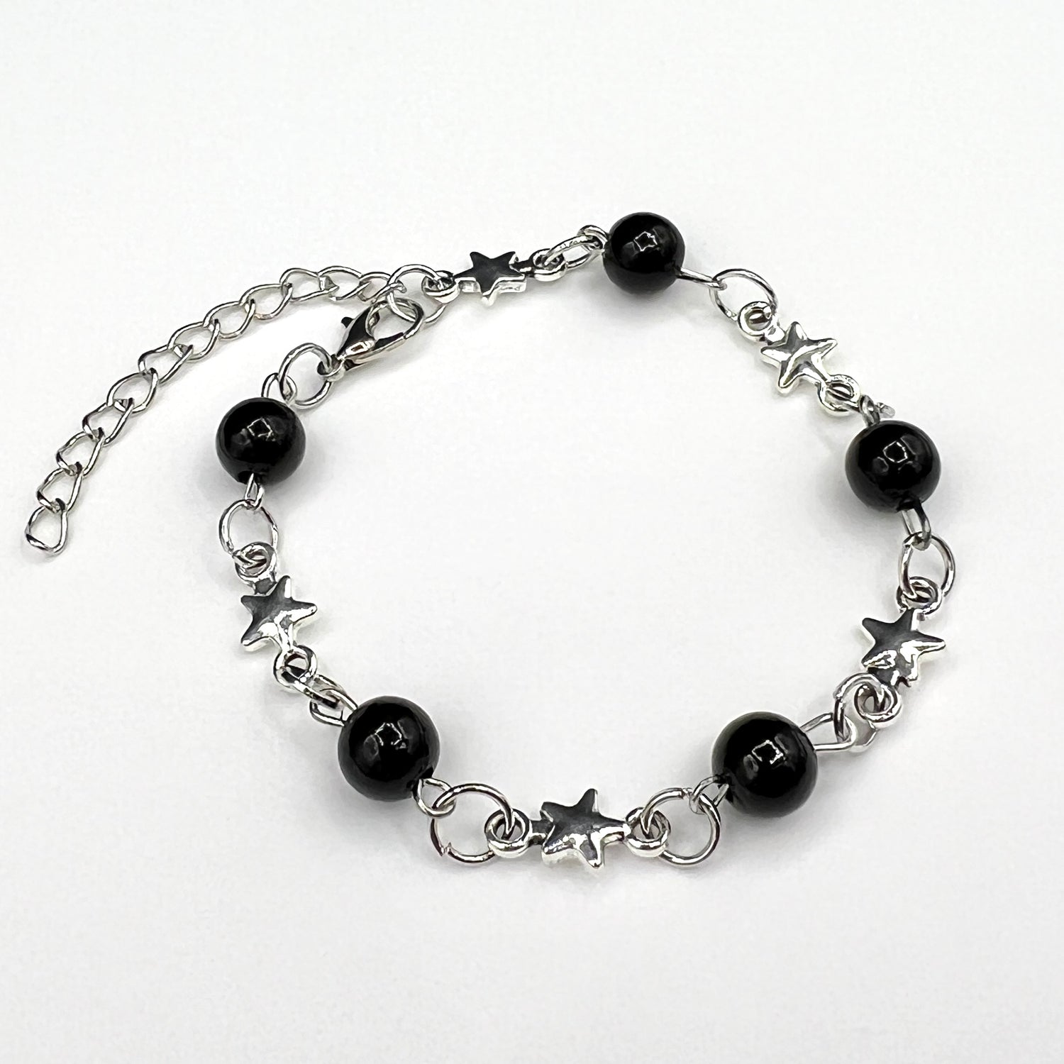 Our Astralis Chain & Bead Bracelet features black onyx beads and a silver star chain design, resulting in a bold silver & black bracelet for men.